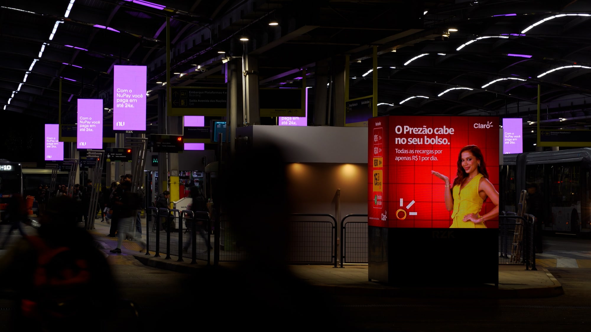 RZK digital out-of-home screens across the Pinheiros urban mobility terminal at night